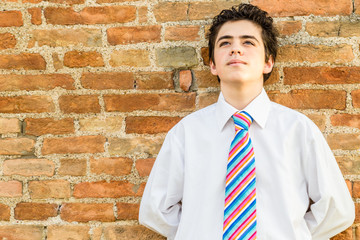 Handsome boy leaning against a brick wall