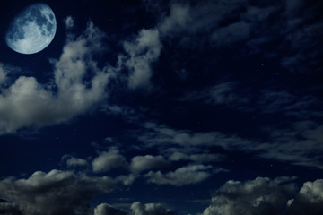 Night blue cloudy sky with stars and a moon