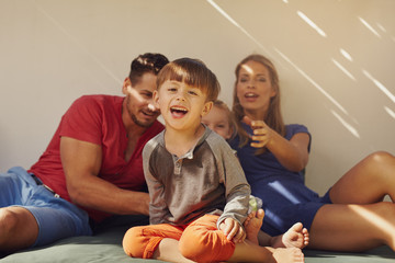 Happy little boy sitting on patio with his family