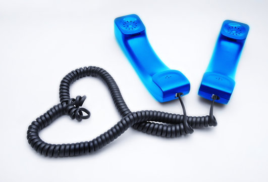 Two handsets with wires woven into a heart-shaped