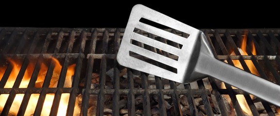 Spatula On The Hot Flaming BBQ Grill Close-up © Alex