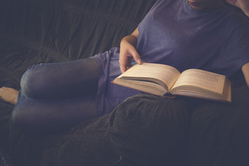 Woman reading a book on a sofa