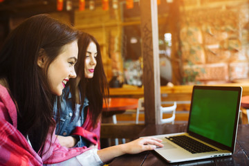 two girls watching something in laptop
