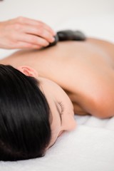 Obraz na płótnie Canvas Pretty woman receiving a hot stone massage