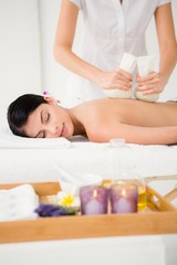 Fototapeta na wymiar Pretty woman enjoying a herbal compress massage