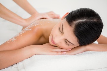 Fototapeta na wymiar Woman enjoying a salt scrub massage