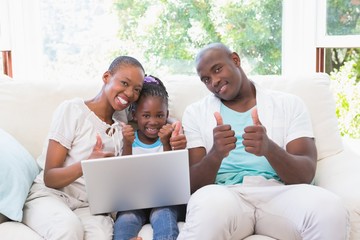 Happy family on the couch with laptop 