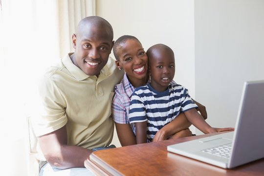 Happy smiling family using laptop 