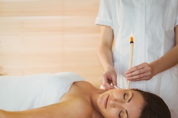 Young woman getting an ear candling treatment