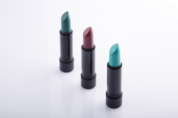 Row of three lipsticks in bold colors