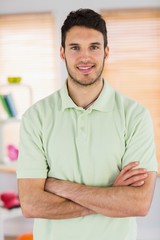 Portrait of smiling handsome masseur with arms crossed