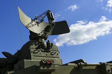 Air defense radar of military mobile mighty rocket launcher system of green color, modern army industry, white cloud and blue sky on background  - obrazy, fototapety, plakaty