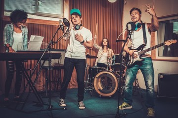 Multiracial music band performing in a recording studio
