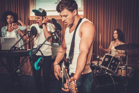 Multiracial music band performing in a recording studio