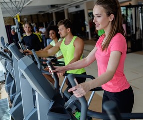 Fototapeta na wymiar People exercising on a cardio training machines in a gym