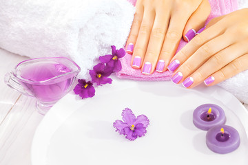 Obraz na płótnie Canvas french manicure with violet flowers. spa