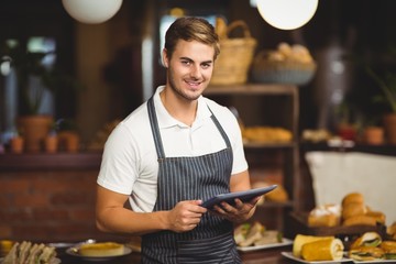 Handsome waiter holding a tablet