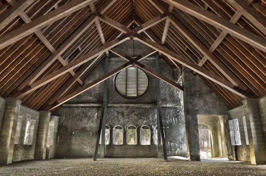 Wide angle interior of old stone church with wood beams.