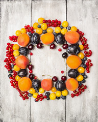 fresh red currants, plums, blackberries,cherry, blueberries, apricots  on a white background , top view, frame