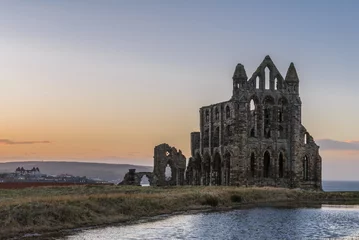 Wall murals Rudnes Stone ruins of Whitby Abbey on the cliffs of Whitby, North Yorkshire, England at sunset.