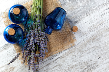 Lavender oil in a glass bottle on a background of fresh flowers