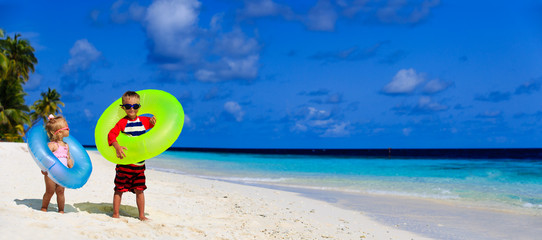cute little boy and toddler girl play on beach