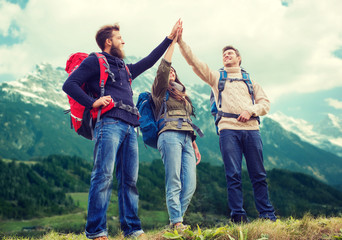 group of smiling friends with backpacks hiking