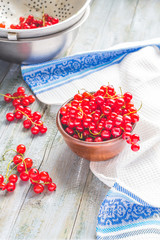 fresh red currants in brown clay piala and metal colander, berry