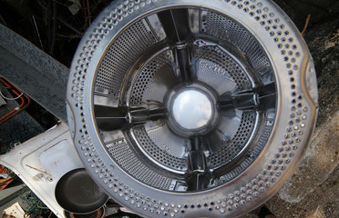 washing machine basket and rusty pieces of iron in the landfill