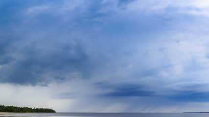 Torrential rain over the lake. Beautiful clouds various shades