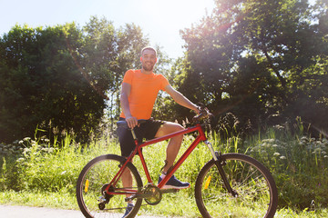 Plakat happy young man riding bicycle outdoors