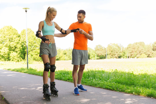 happy couple with roller skates riding outdoors