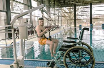 Disabled man in a swimming pool. Wheelchair. Disabled person in a wheelchair.