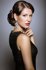 Fototapeta premium Beautiful girl with red lips in black clothes in the form of retro. Beauty face. Picture taken in the studio on a gray background.