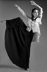 Girl in stylish clothes. Beauty, fashion, original poses. Picture taken in a studio full-length. Black and white photo