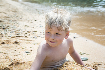 Child playing in the sand on the beach