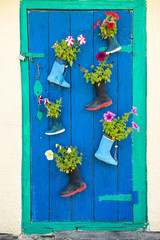 Fototapeta na wymiar Old rubber boots with blooming flowers