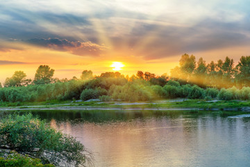 Obraz na płótnie Canvas Beautiful sunset above a big river