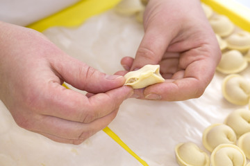 cooking process ravioli person close-up with dough and meat