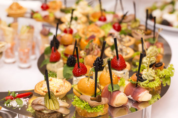 Canapes of cheese vegetables meat and seafood on white background