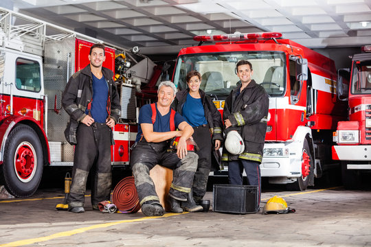 Happy Firefighter's Team With Equipment At Fire Station