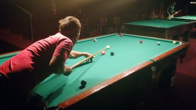 Homem jogando sinuca em bar