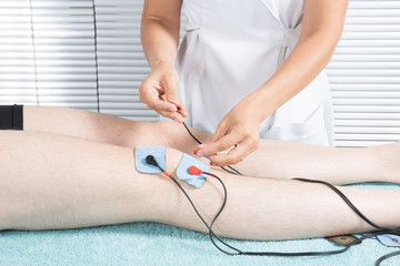 Man with electrostimulator electrodes on his body