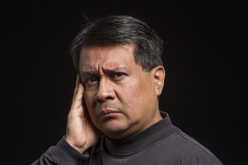 Studio portrait of a worried Hispanic male