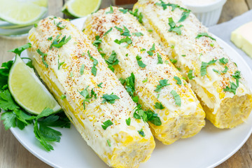 Mexican corn with butter, mayonnaise, parmesan, chili, cilantro, and lime