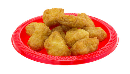 Chicken nuggets on a small red plate