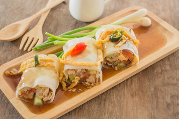 Spring rolls with vegetables and chicken on wooden plate