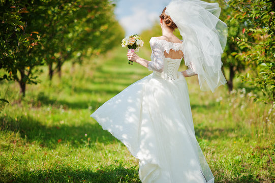 Gentle bride walking at apple garden