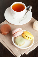 Colorful French Macaroon with Cup of Tea on black background