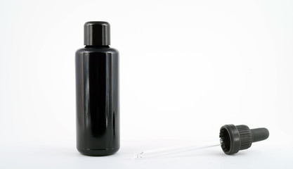 Black perfume bottle with a pipette on a white background
